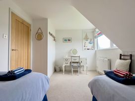 A bedroom with two beds and a desk at Kilcarreg in Rock near Wadebridge