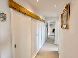 A hallway with doors and a wooden beam at Kilcarreg, Rock near Wadebridge