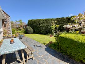 A garden with a table and plants at Kilcarreg in Rock near Wadebridge