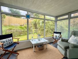 A conservatory with chairs and a table at Kilcarreg in Rock near Wadebridge