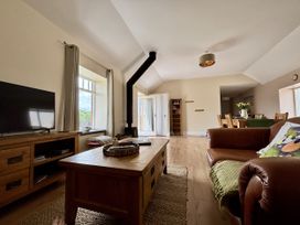 A living room with a television and coffee table at Llaethdy - The Dairy Boncath near Crymych
