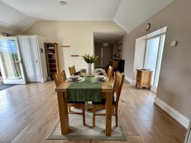 A dining room with a table set for meals at Llaethdy - The Dairy Boncath near Crymych