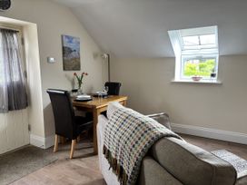 A living room with a dining table and chairs at Lloft Gwair - Hayloft Boncath near Crymych