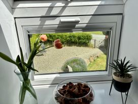 A window with tulips and a decorative bowl at Lloft Gwair - Hayloft in Boncath near Crymych