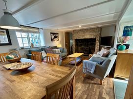 A living room with a fireplace and dining table at 14 Boscaswell Downs Pendeen near St Just