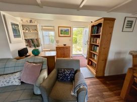 A living room with a sofa and bookshelf at 14 Boscaswell Downs in Pendeen near St Just