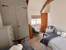 A bedroom with a wardrobe a dresser and a chair at 14 Boscaswell Downs Pendeen near St Just