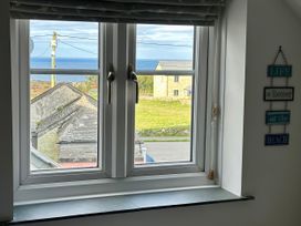 A window with a view of the ocean and grass at 14 Boscaswell Downs Pendeen near St Just