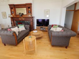 A living room with two sofas a wooden coffee table a side table a wooden fireplace and a television at Menai View near Menai Bridge