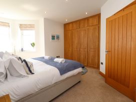 A bedroom with a double bed and built in wooden wardrobes at Menai View near Menai Bridge