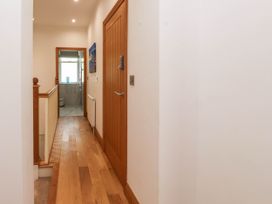 A hallway with wooden flooring and doors leading to other rooms at Menai View near Menai Bridge