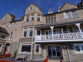 A multi-story stone building with stepped gable roofs and white balcony near Menai Bridge