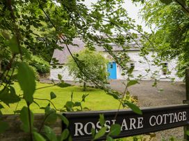 A cottage with a blue door and garden at Rosslare Cottage in Broughshane