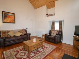 A living room with sofa and coffee table at Rosslare Cottage Broughshane