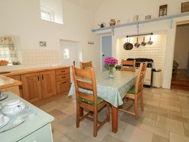 A kitchen with a dining table and chairs at Rosslare Cottage Broughshane