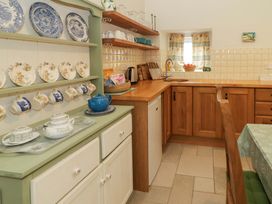 A kitchen with teapot and plates displayed at Rosslare Cottage Broughshane