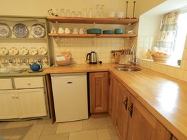 A kitchen with wooden cabinets and appliances at Rosslare Cottage Broughshane
