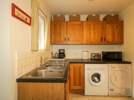 A kitchen with cabinets, sink, and appliances at Rosslare Cottage in Broughshane
