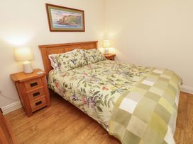A bedroom with a bed and nightstand at Rosslare Cottage Broughshane