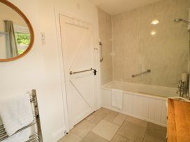 A bathroom featuring a bath tub and a towel rail at Rosslare Cottage in Broughshane