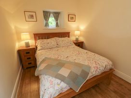 A bedroom with a bed and bedside tables at Rosslare Cottage, Broughshane