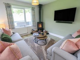 A living room with a fireplace and sofas at Yew - Woodland Cottages Bowness-On-Windermere
