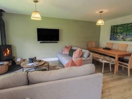 A living room with a sofa and dining table at Yew - Woodland Cottages Bowness-On-Windermere
