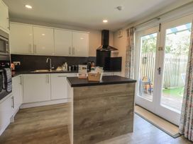 A kitchen with modern appliances and a door leading to a deck at Yew - Woodland Cottages in Bowness-On-Windermere