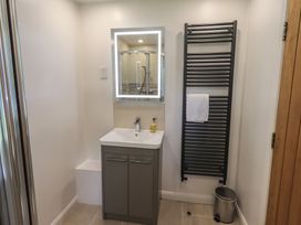 A bathroom with a sink and mirror at Yew - Woodland Cottages in Bowness-On-Windermere
