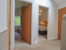 A hallway with doors leading to bedrooms at Yew - Woodland Cottages in Bowness-On-Windermere