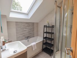 A bathroom with a shower and bathtub at Yew - Woodland Cottages in Bowness-On-Windermere