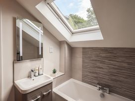 A bathroom with a bath and sink at Yew - Woodland Cottages Bowness-On-Windermere