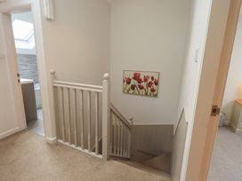 A staircase with wall art and a door at Yew - Woodland Cottages in Bowness-On-Windermere