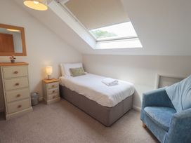 A bedroom with a single bed and bedside table at Yew - Woodland Cottages Bowness-On-Windermere
