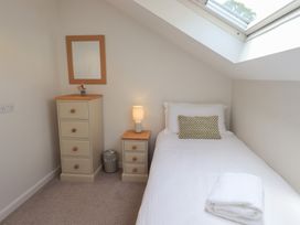A bedroom with a single bed and dresser at Yew - Woodland Cottages Bowness-On-Windermere