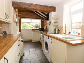 A kitchen with a wooden countertop and a washing machine at Fern Cottage in Heacham