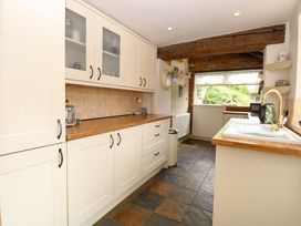 A kitchen with cabinets and appliances at Fern Cottage Heacham