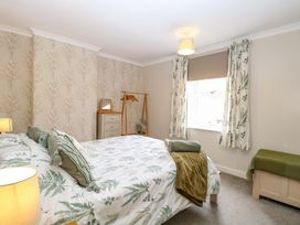 A bedroom with a bed and bedside table at Fern Cottage Heacham