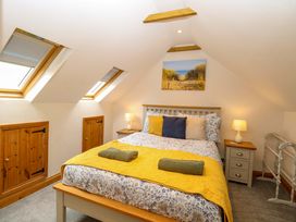 A bedroom with a bed and skylights at Fern Cottage in Heacham