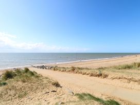 A beach with sand and sea at Fern Cottage in Heacham