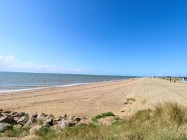 A beach with sand and sea at Fern Cottage in Heacham