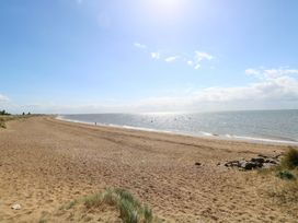 A beach with sand and sea at Fern Cottage in Heacham