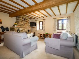 A living room with a fireplace and sofa at 4 Mowhay Cottages in Gorran Haven