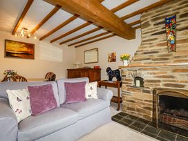 A living room with a sofa and a fireplace at 4 Mowhay Cottages Gorran Haven