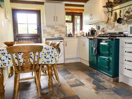 A kitchen with a table and chairs at 4 Mowhay Cottages in Gorran Haven