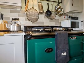 A kitchen with an oven and various utensils at 4 Mowhay Cottages in Gorran Haven