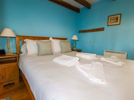 A bedroom with a bed and bedside lamp at 4 Mowhay Cottages Gorran Haven