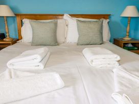 A bedroom with a bed and towels at 4 Mowhay Cottages in Gorran Haven