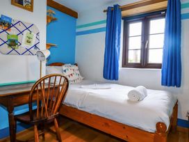 A bedroom with a bed and desk at 4 Mowhay Cottages Gorran Haven