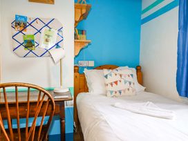 A bedroom with a bed and desk at 4 Mowhay Cottages in Gorran Haven